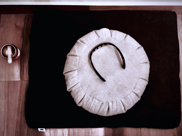 Zafu meditation cushion on a zabuton mat with the Muse 2 headband and a signing bell